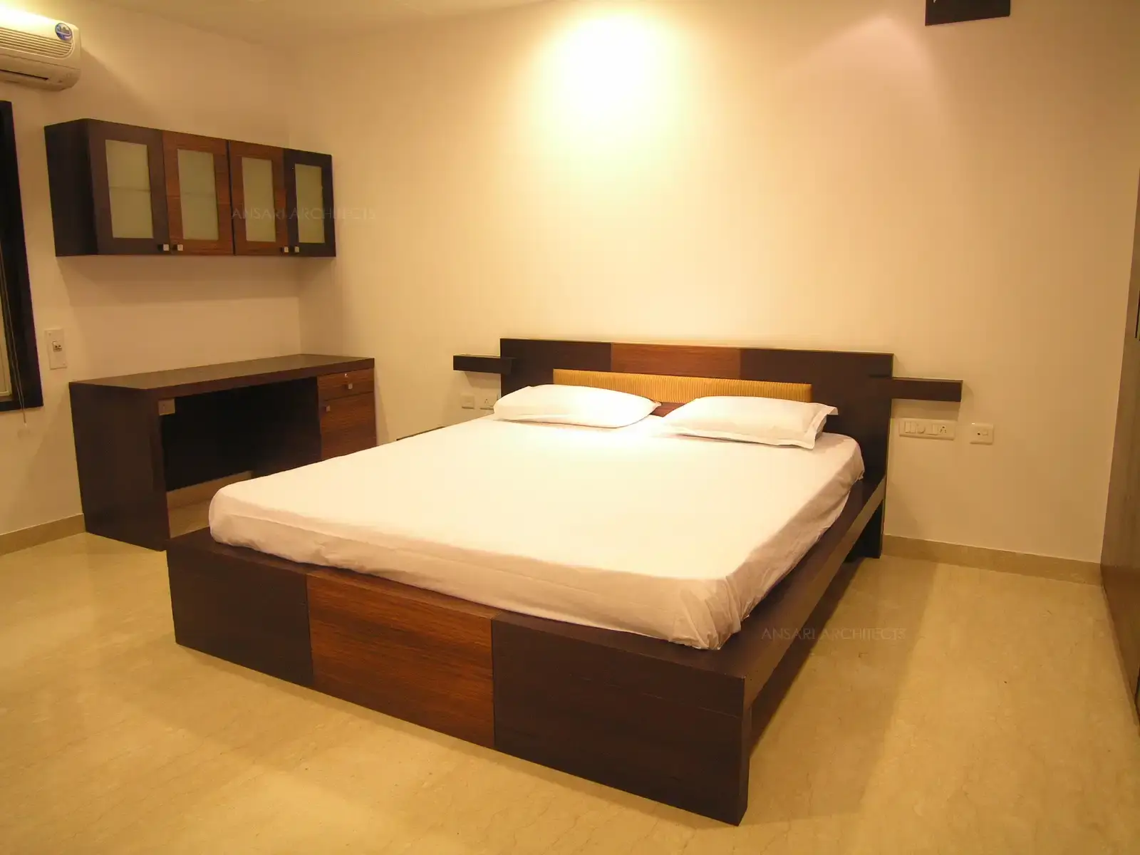 Bed in the guest room is simple and sleek with comfortable backrest.