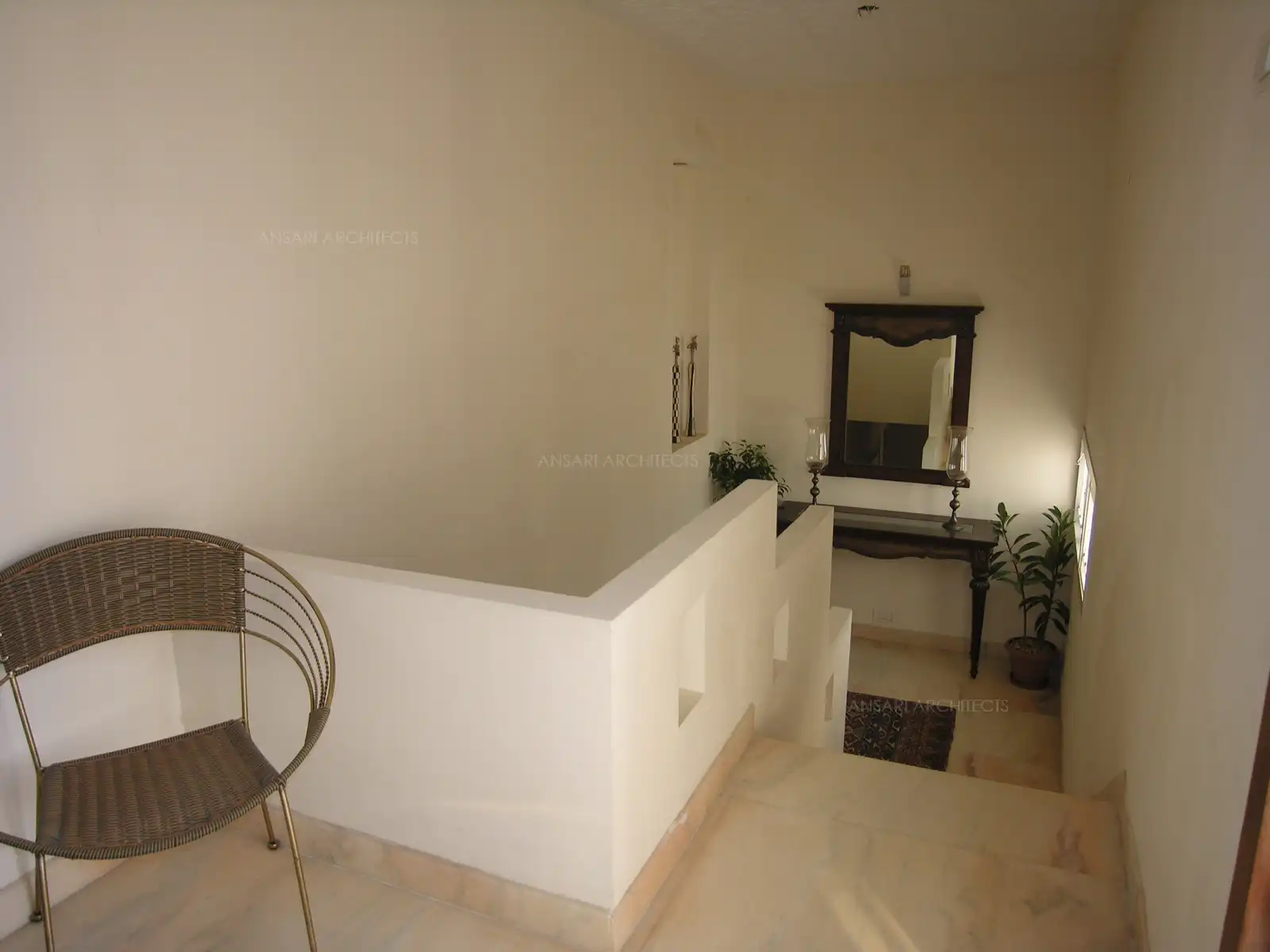 View of staircase area and mid landing with some classic furniture.