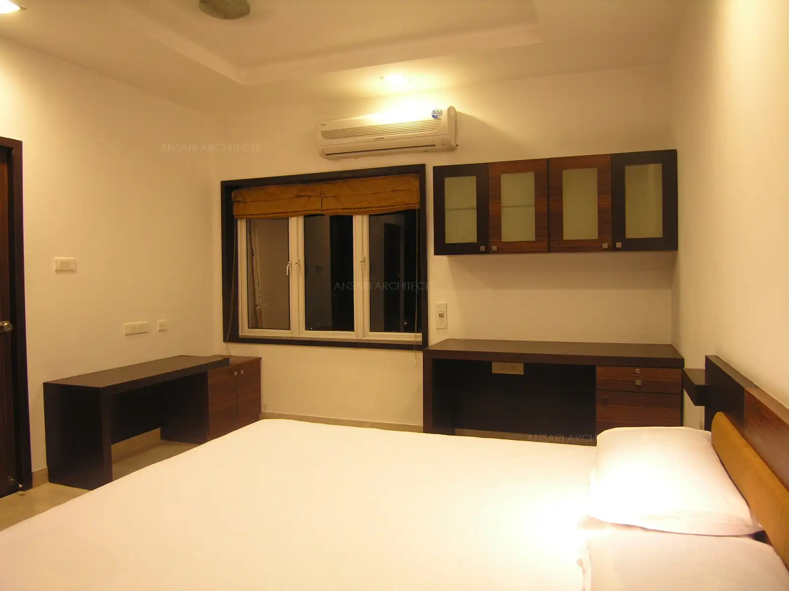 Wide TV unit also acts as a utility table in this guest bedroom.