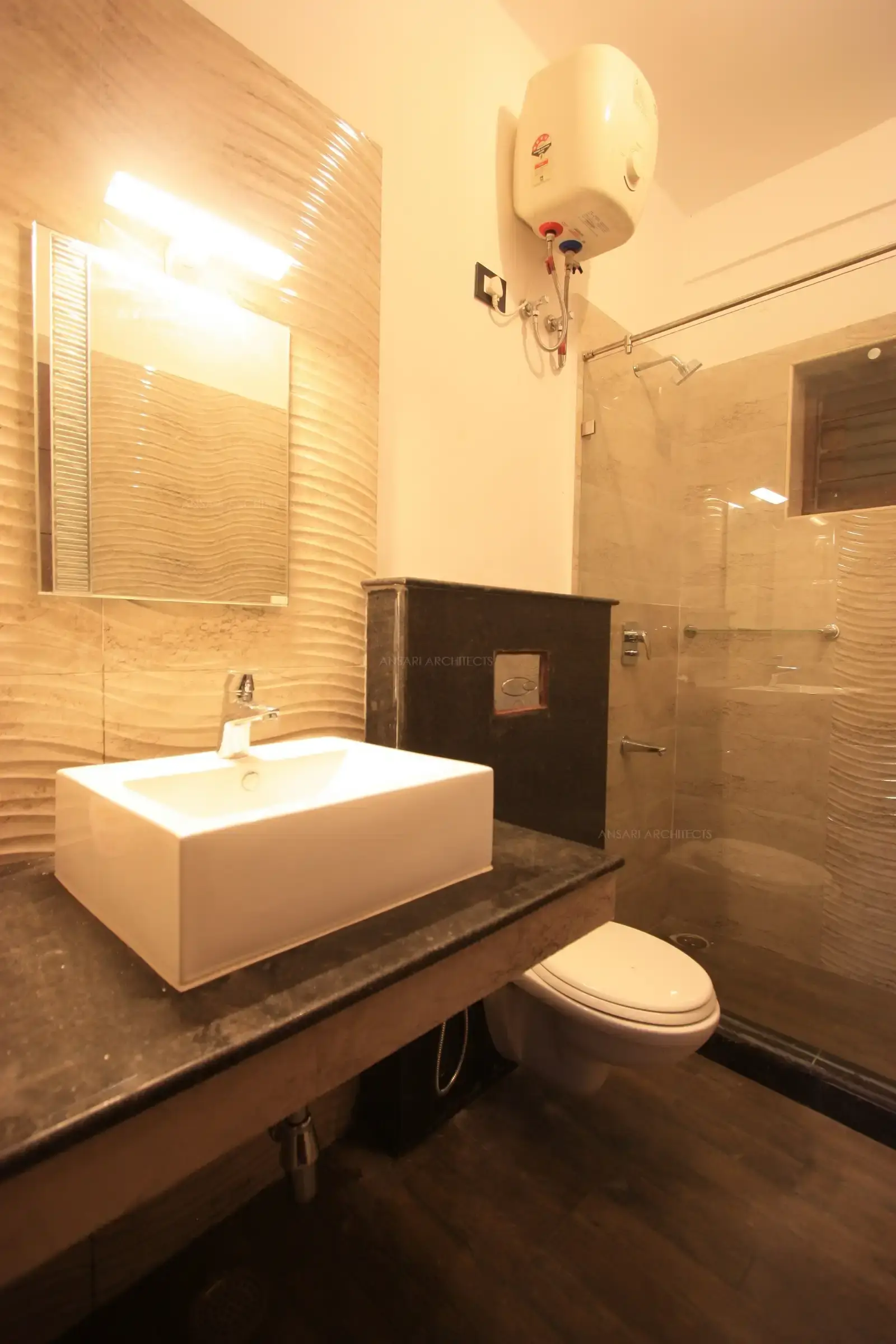 The toilet has neutral colour scheme with textured wall tiles to to give an interesting look feature.