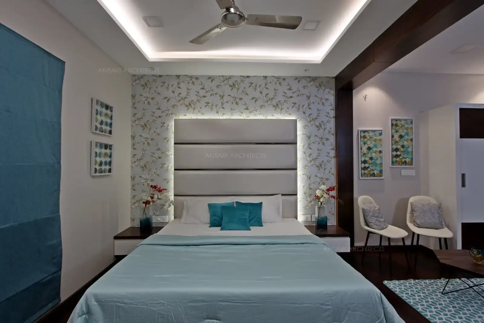 Recessed lights further lifts up the space, the backdrop wall is highlighted with wallpaper with golden leaf patterns that provide a royal outlook. Dark wooden flooring provides more warm look.
