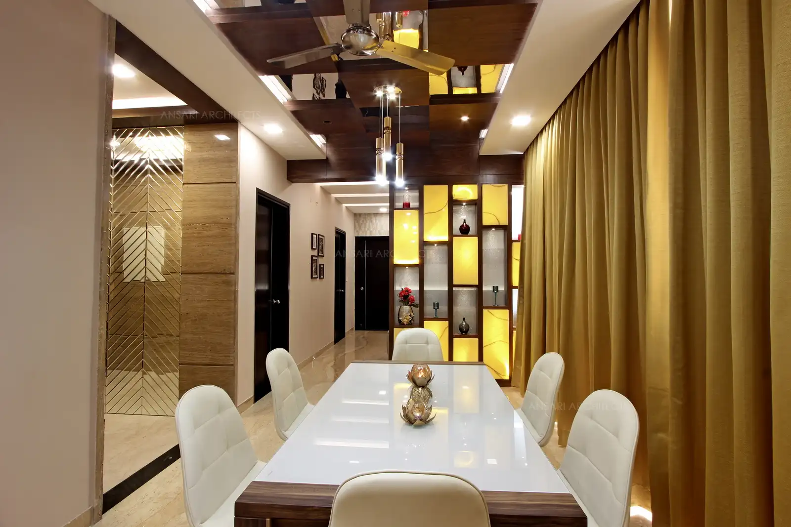 The dining table with cushioned seaters, the white shades adds to the visual relief.