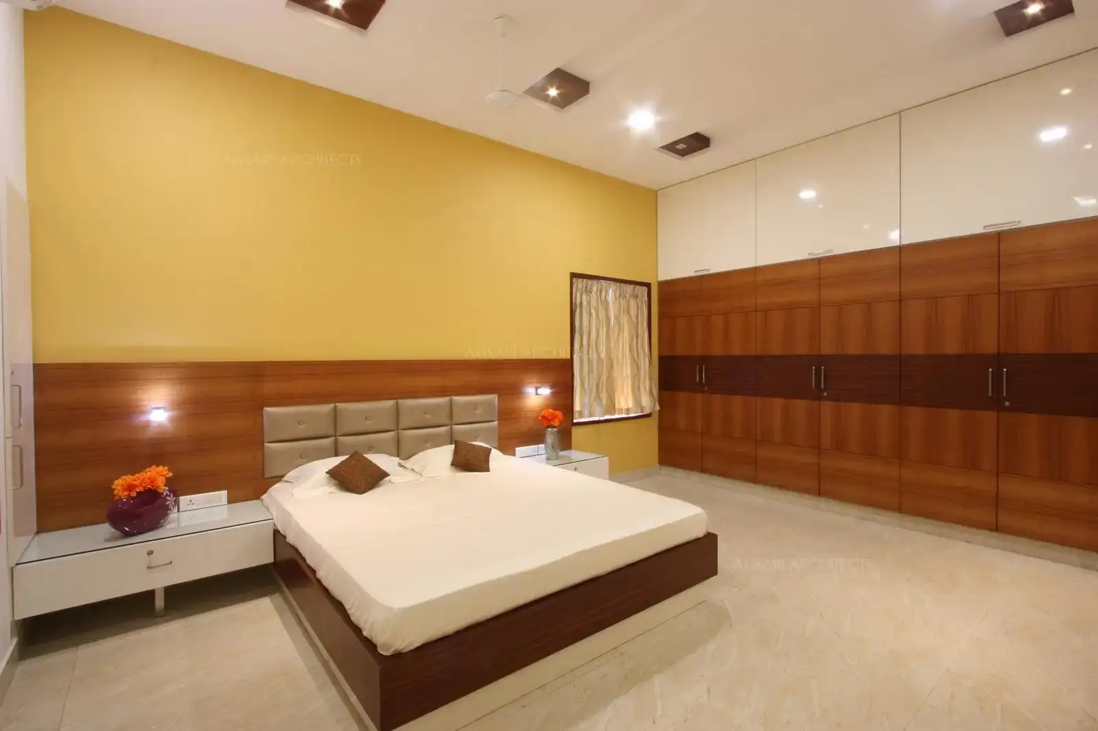 The design accomodates wardrobe units offering plenty of storage and easy use with white lacquered cabinets covering the entire stretch of the wall, giving the room character and a certain edge.