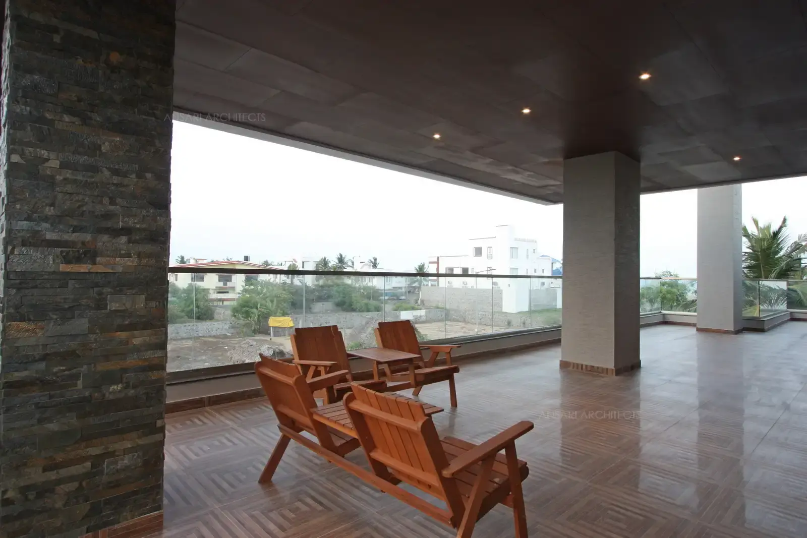 The sitout is large and spacious, with specific patterned tiles that create a dramatic effect, with highlighting stone textures on columns, lights provide a soft glow to the space with providing depth for the texture.