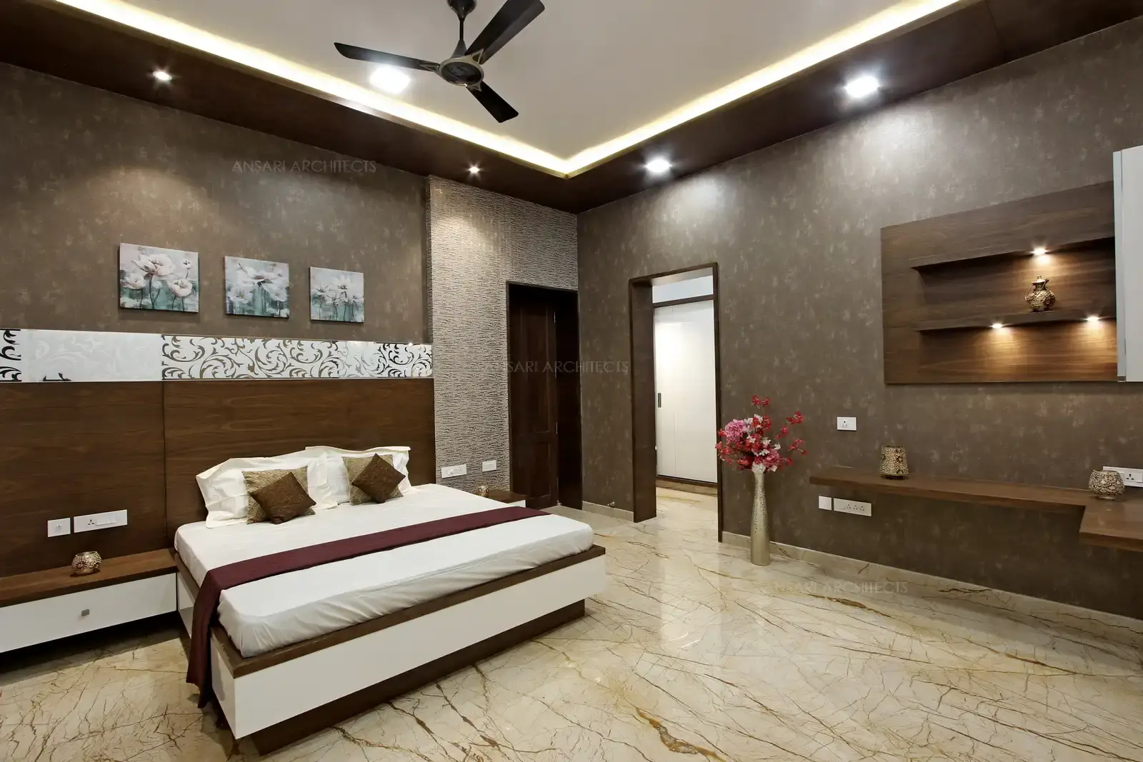Wooden panelling creates a solid outlook and the patterns create a royal outlook along with selected artifacts . Functional table provisionand table is sleek . Selected artifacts are chosen for the bedroom.