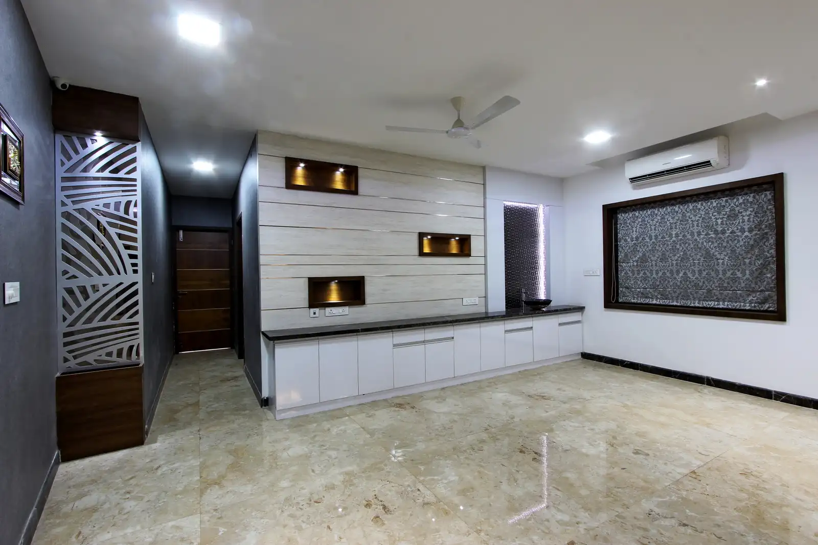 The walls are adorned with veneer niches and niche lights that create illumination with counters with granite top and storage cabinets creating seamless integrated look.