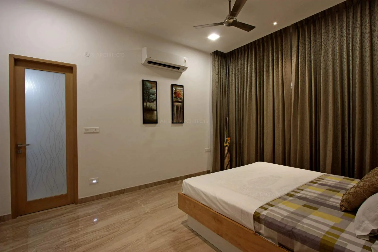 Large windows with curtain drapes, the marble flooring looks serene ,the wall painting features scenery image evokes natural settings for the theme of the bedroom.