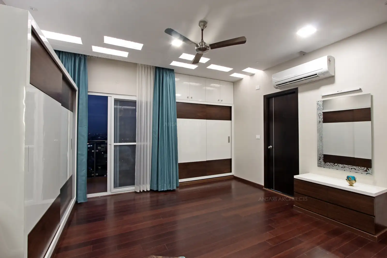 Rectangular array strip lights that are composed in a decent pattern renders an eclectic finish, Vanity unit looks sleek with veneer texture and mirror.