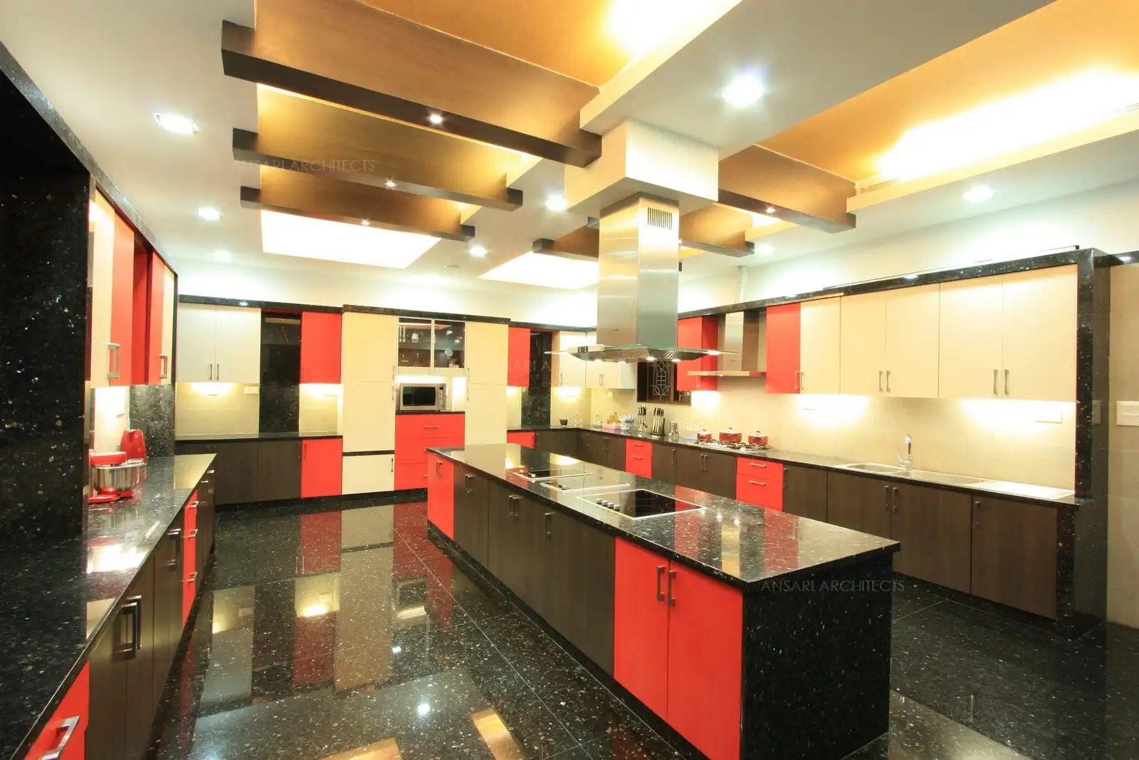 View of kitchen showing the island counter and wooden false ceiling with bright lightings.