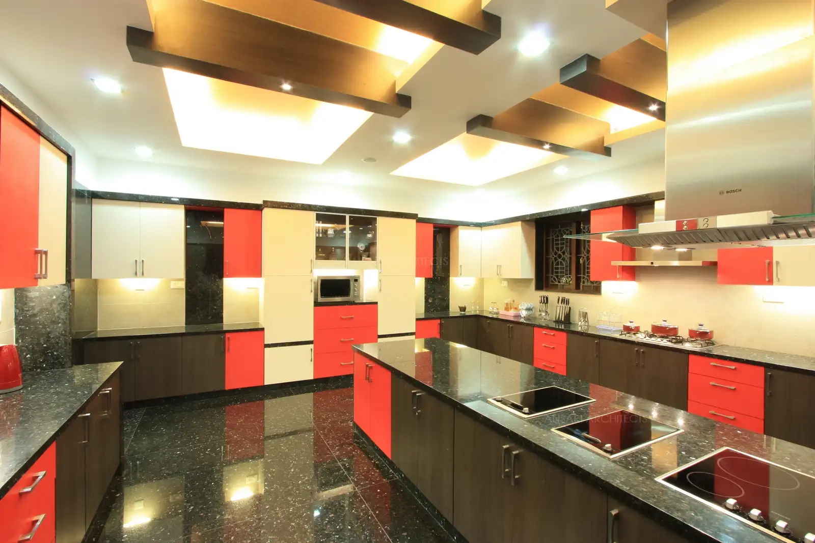 View of kitchen showing the island counter and wooden false ceiling with bright lightings.