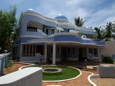 a blue and white house with a fountain