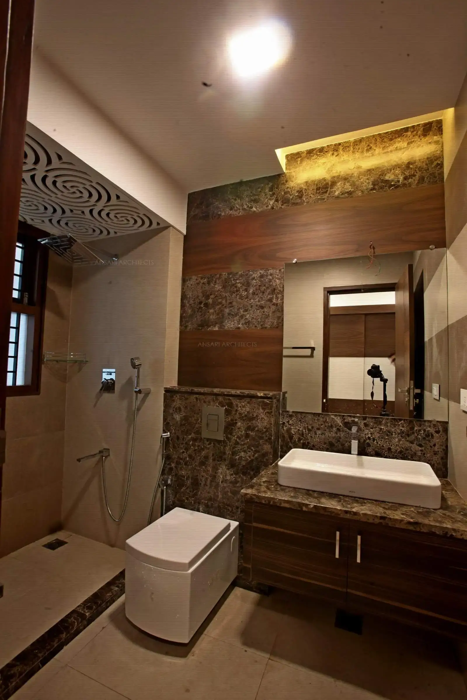 The stone tiles provide a seamless effect and has a sense of luxury with a surface mounted basin . The custom made vanity unit provides storage below. Entirely a muted colour scheme which works perfectly.