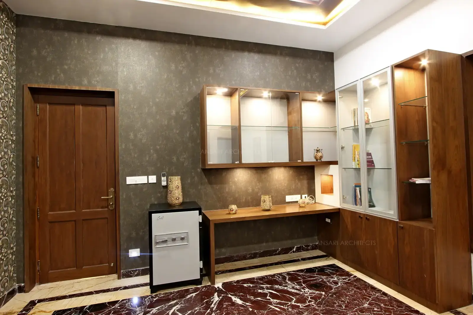 The study area has been designed with a bold finish , a solid outlook. The book shelves arranged with glass racks and wood makes it complete.Lighting is very perfect for the space for reading and writing.