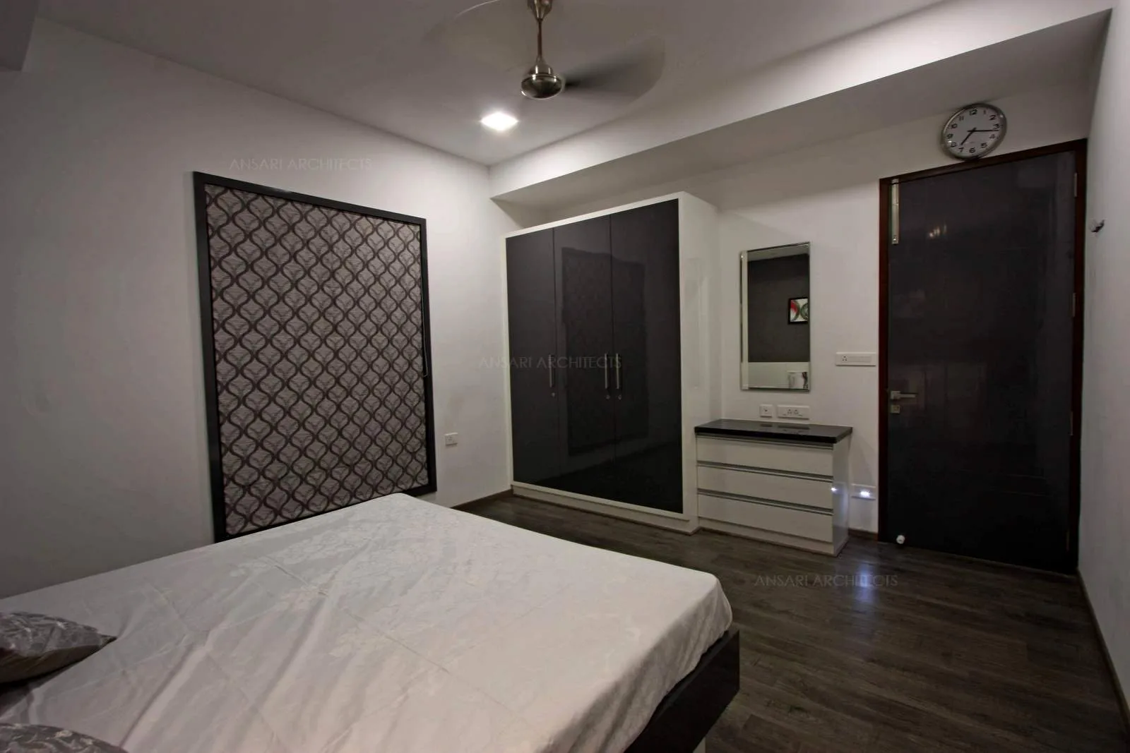 Luxury of connecting the wardrobe and vanity unit, the dark tones add contrast to the smoothness of the white walls. Dark tones bring in a sense of warmth to the room.