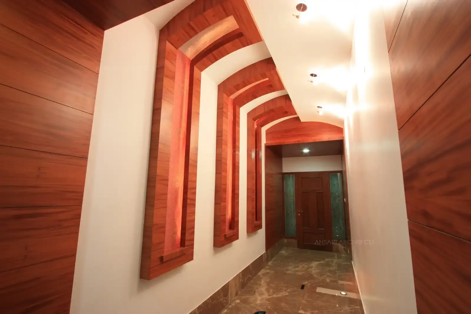 Passage leading to ladies living is designed in wooden panelling and niches with concealed lights.