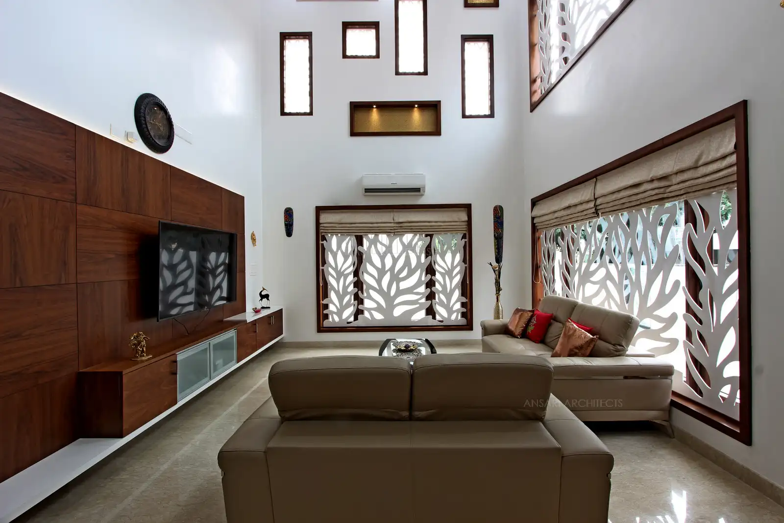Living is set perfect natural lighting and muted colours, cosy cushions that balance colours. Walls provide interest with mood influencing accessories, floral grill patterns for windows which looks delicate. Floral patterns on glass coffee table with a more tropical feel.