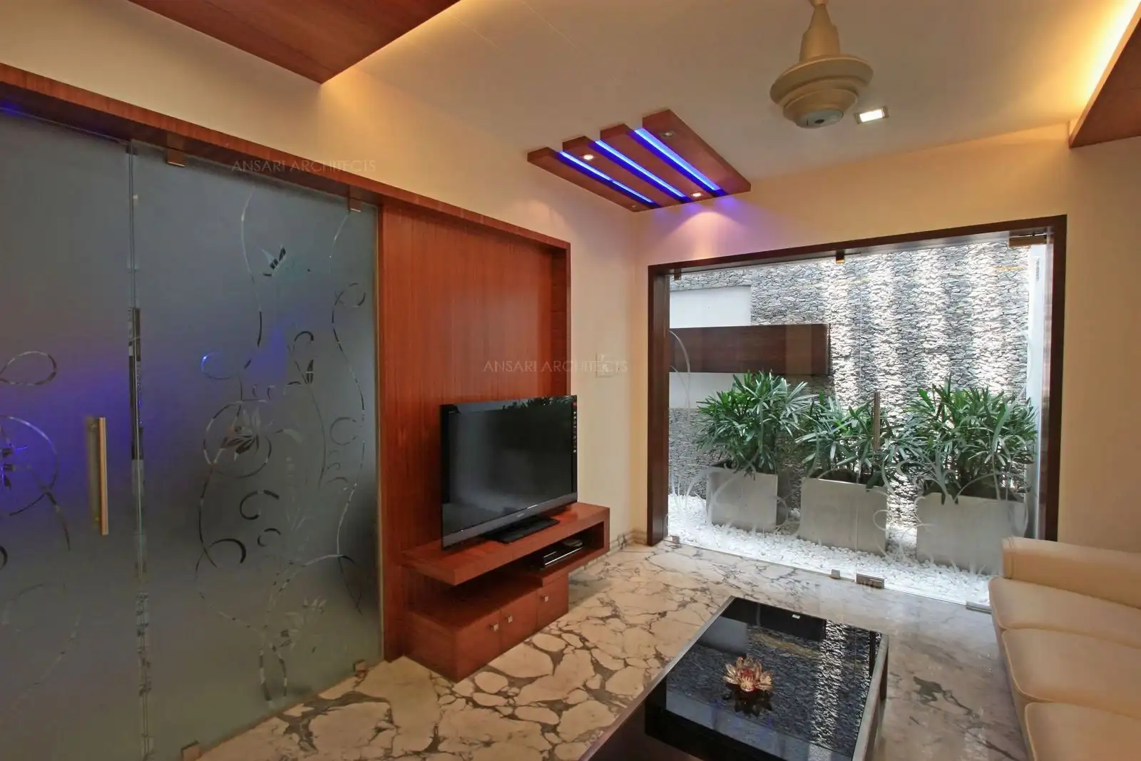 Contemporary looking Interior designed in this drawing room with the use of simple wall panelling and glass.
