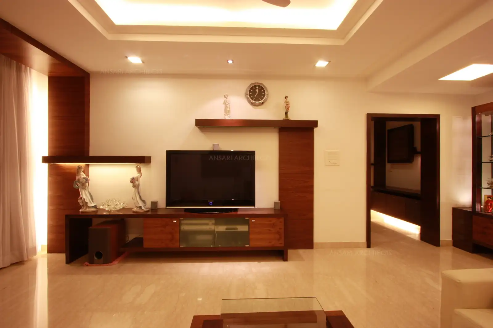 TV unit in the living room has been designed in contemporary style with ample amount storage and display unit.