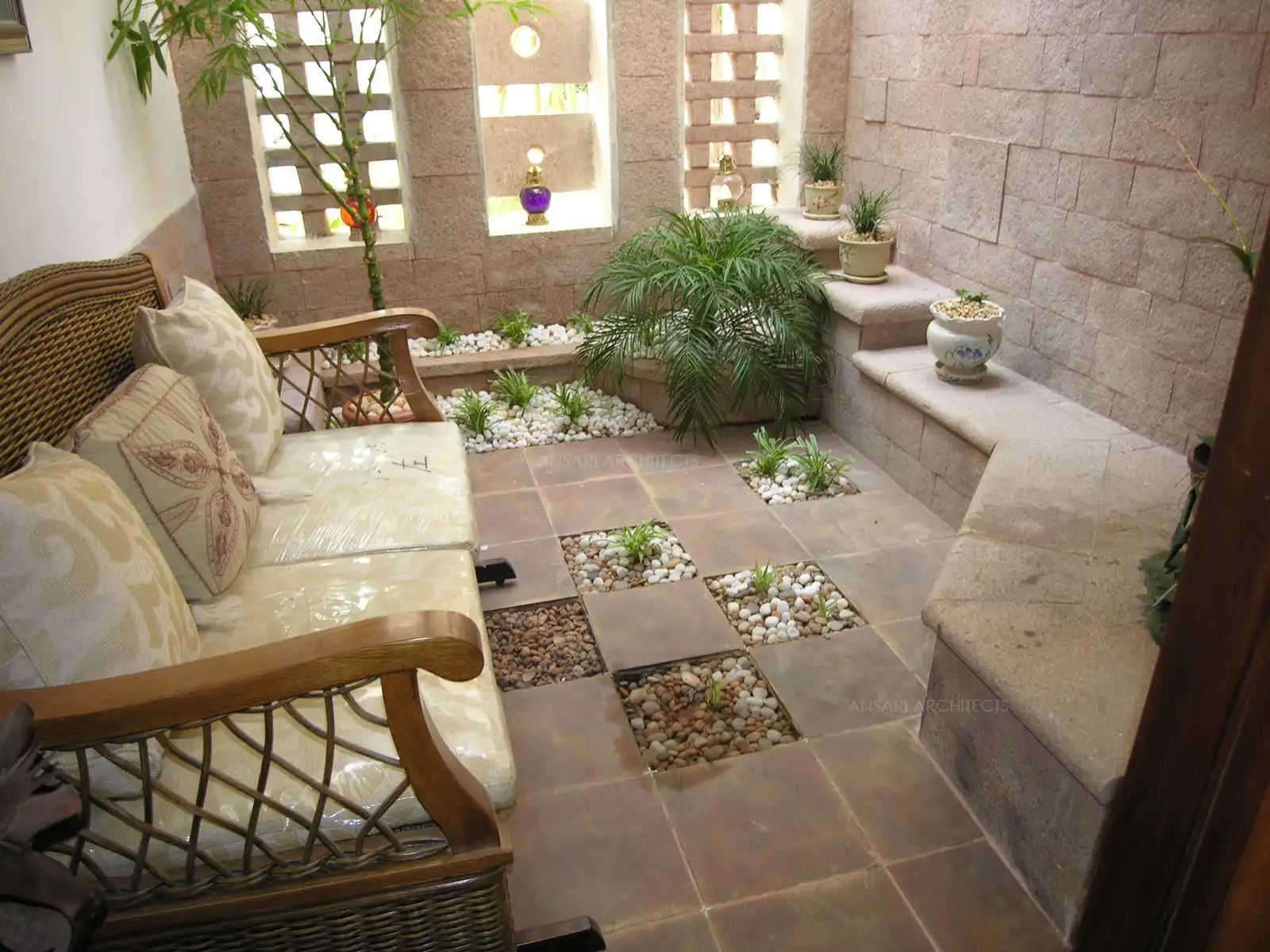 Natural stone and wooden seating provided in the courtyard.