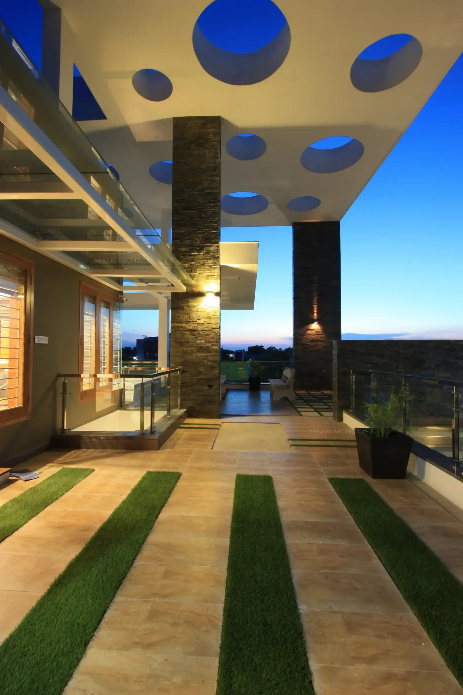 The balcony's handrails are designed in stainless steel and glass with glass canopies surrounding the doors and windows.