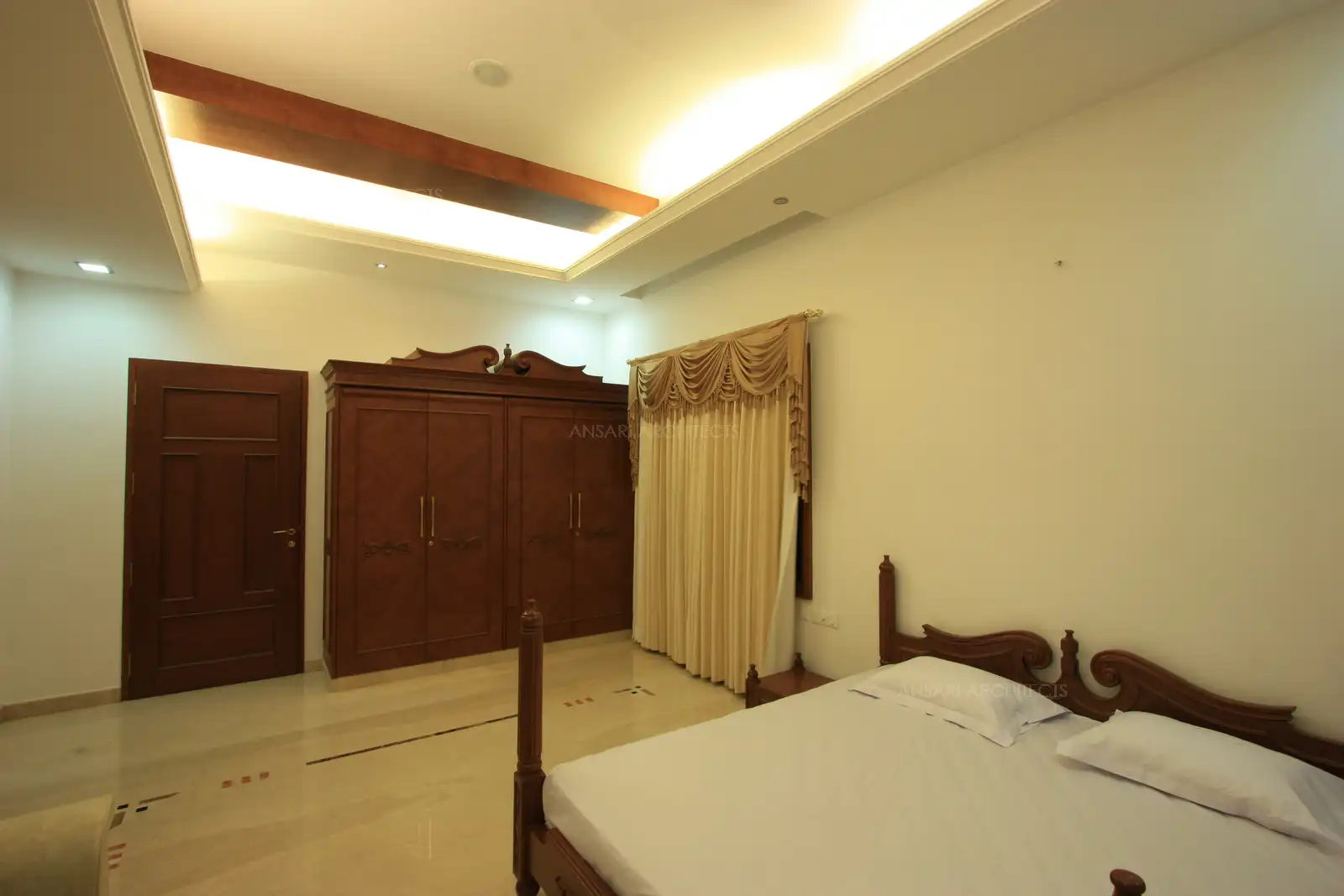 Curved profile of the bed follows in the wardrobe giving a classic touch to the interiors.