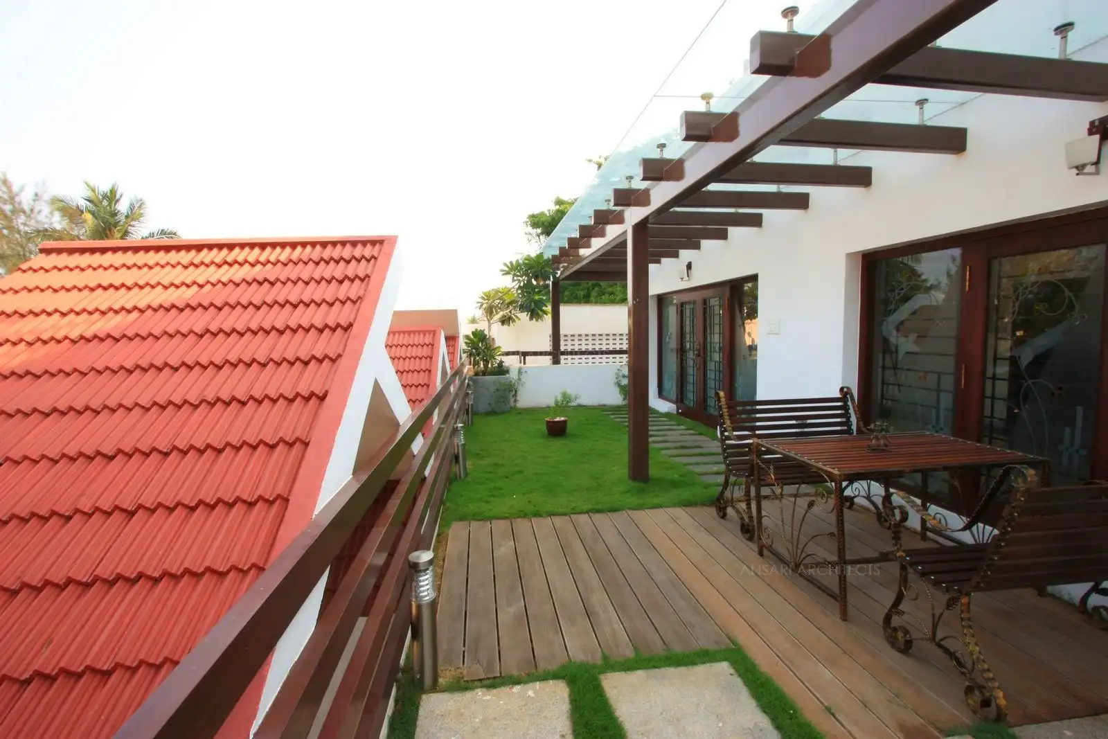 View of terrace garden in the second floor showing the seating area on wooden deck surrounded by artificial grass turf.