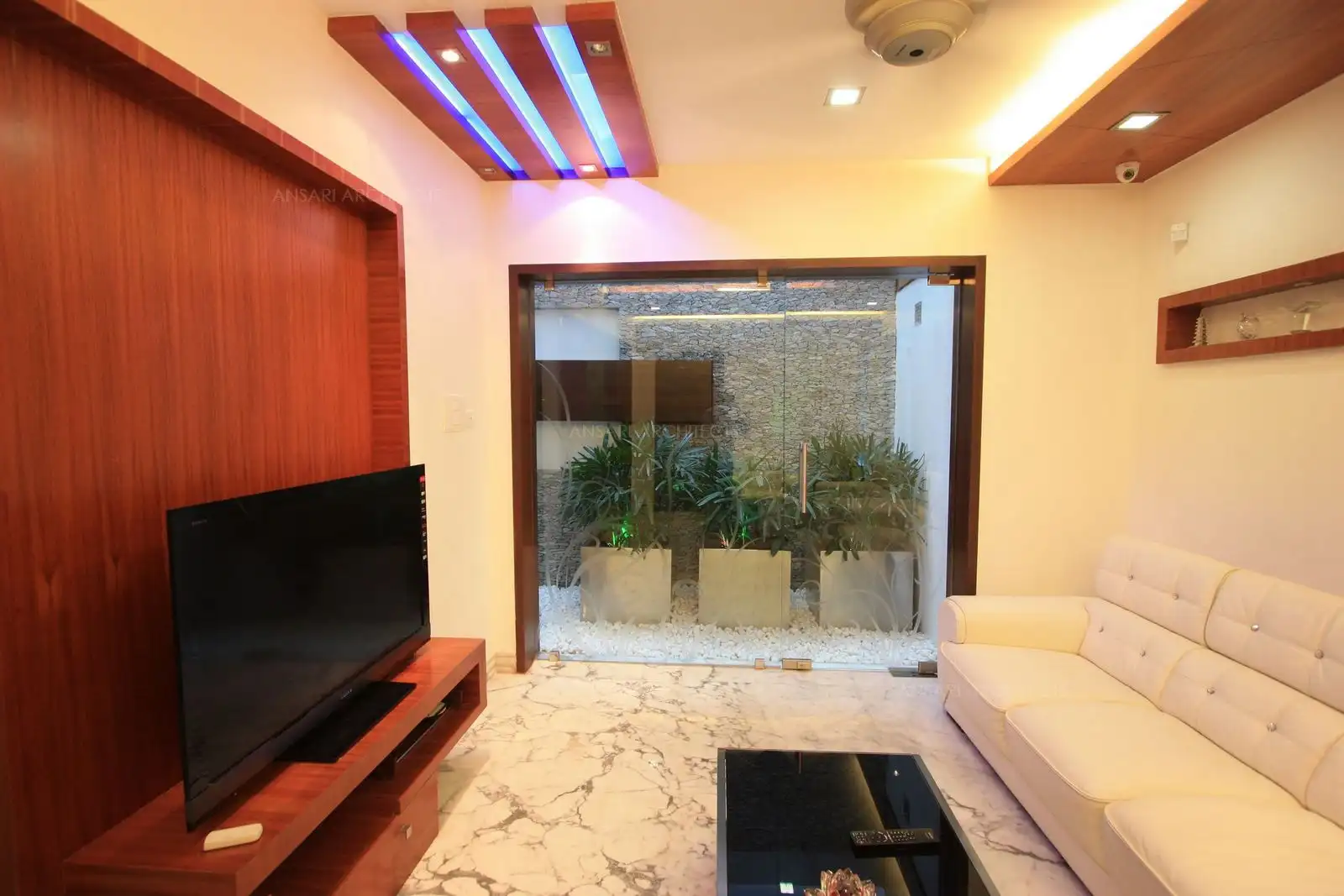 Drawing room in the ground floor gets view of the beautiful courtyard through a glass door and partition.