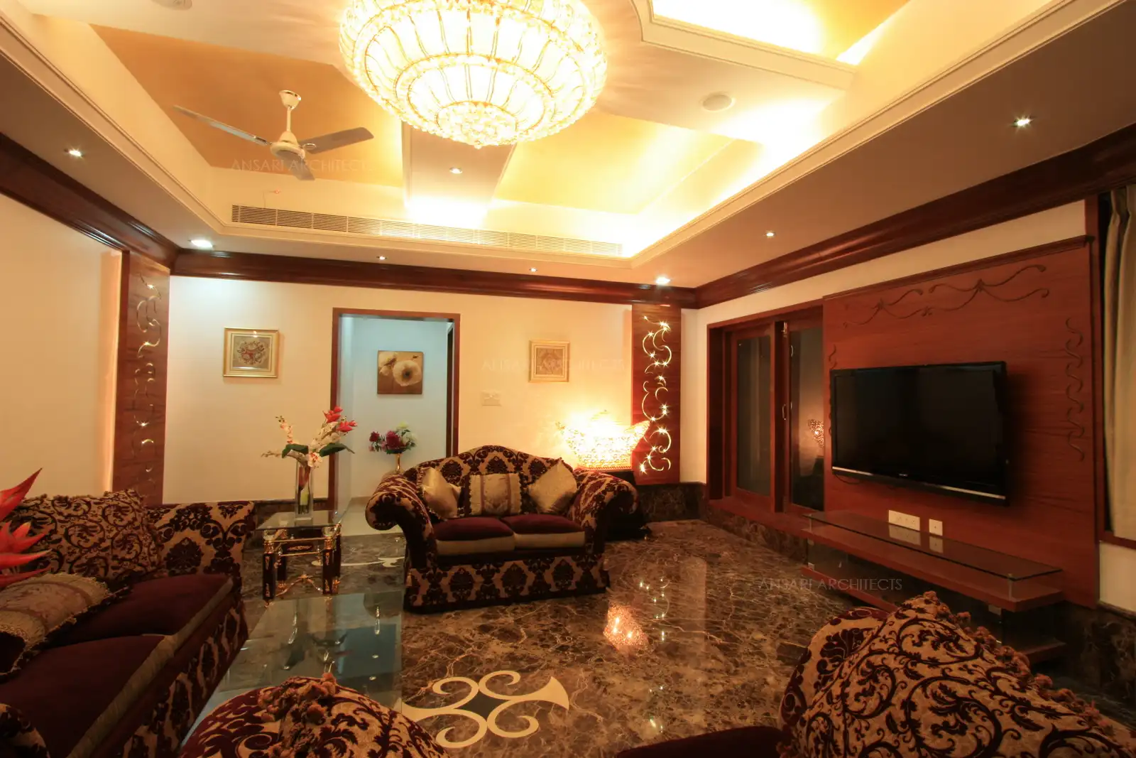 Drawing room has been designed in intricate laser cut wooden panels, wooden cornices and rich false ceiling.