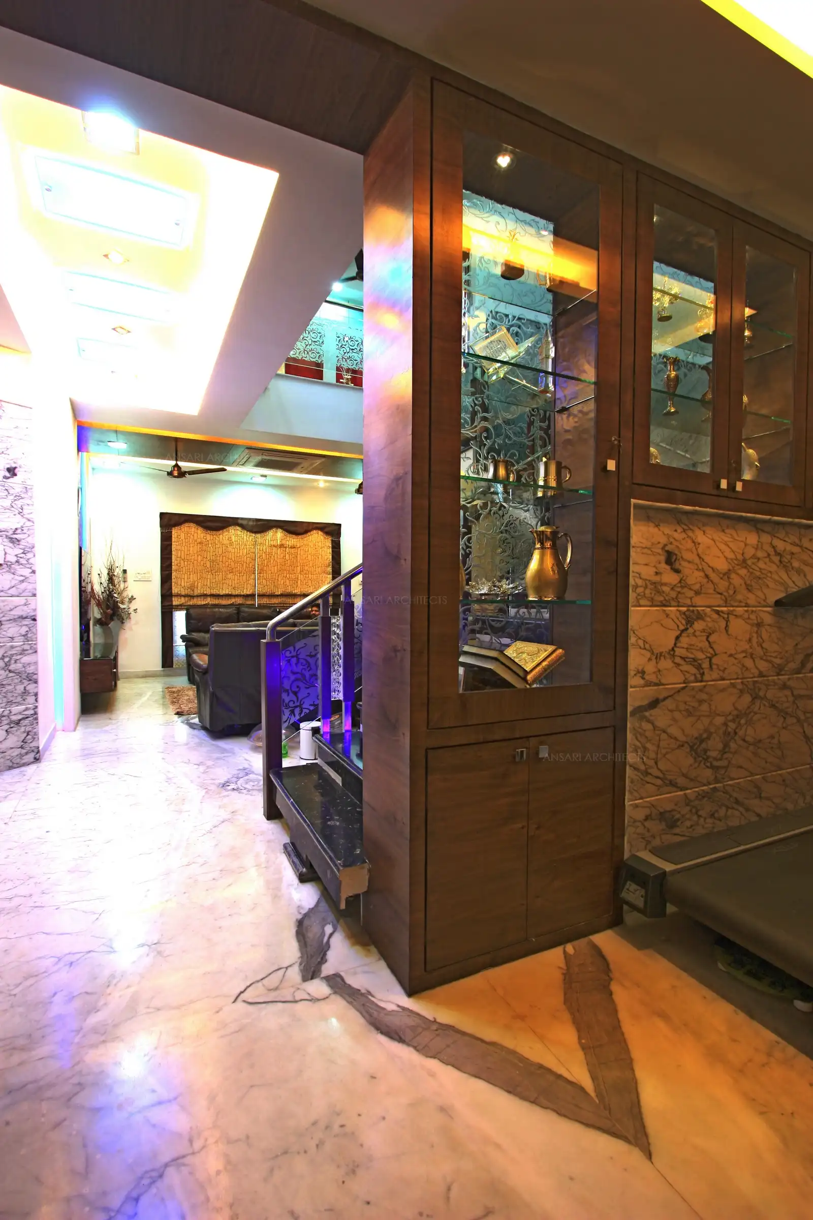 View of living area seen from the dining room divided by a display partition and staircase