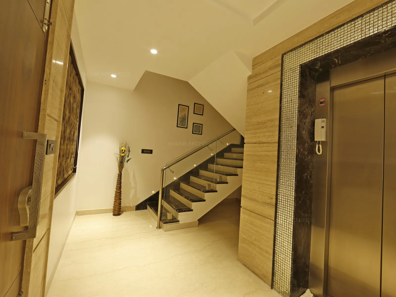 The lobby has its own way of golden rendering spot lights ,the lift area is framed up with silver lining and marbles covers the rest. Stairs begin with photo montages and glass handrails provides lightness and achieves a seamless look.