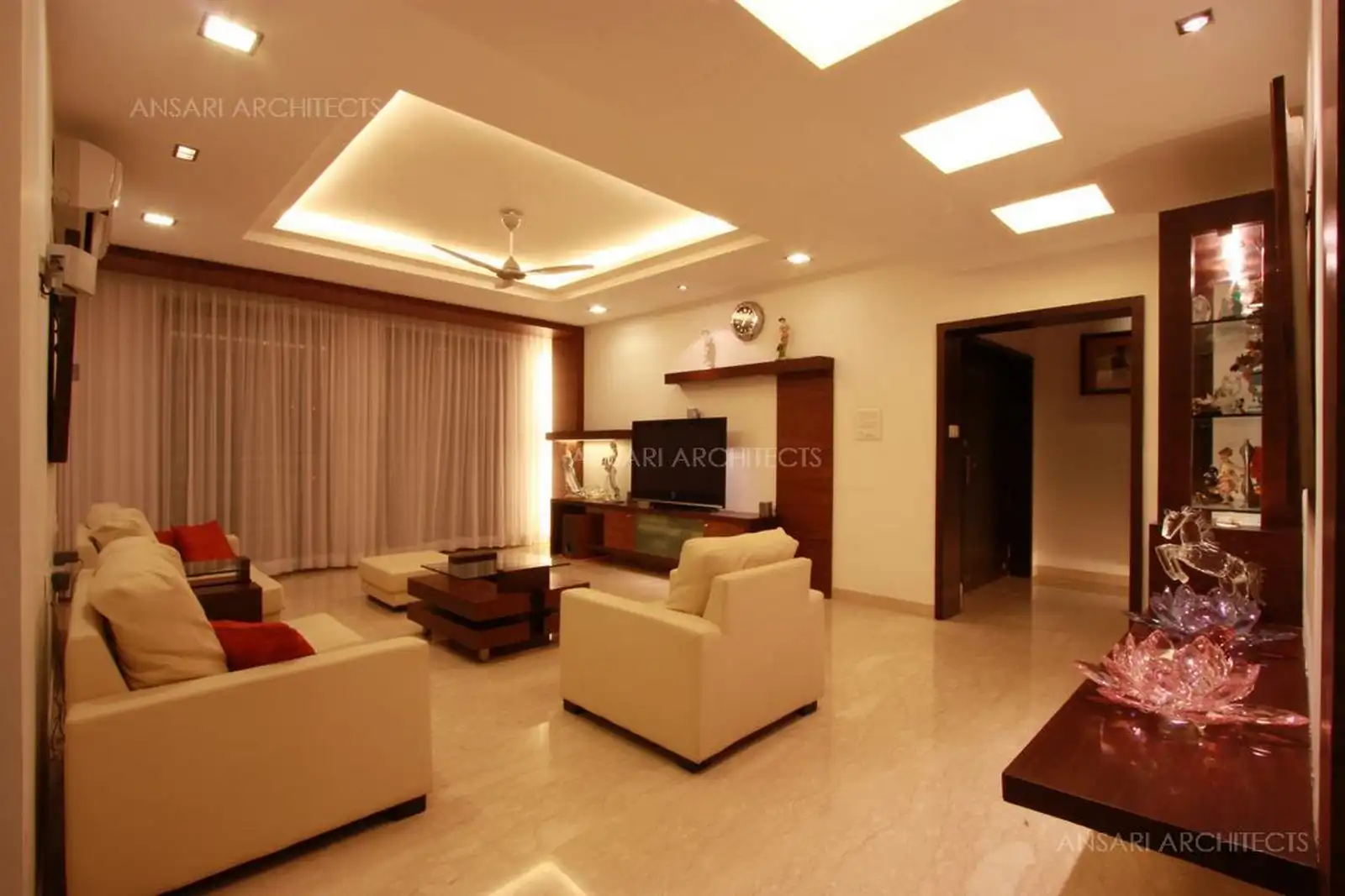Sleek and simple lines created in false ceiling at different level gives a contemporary look in this living room.