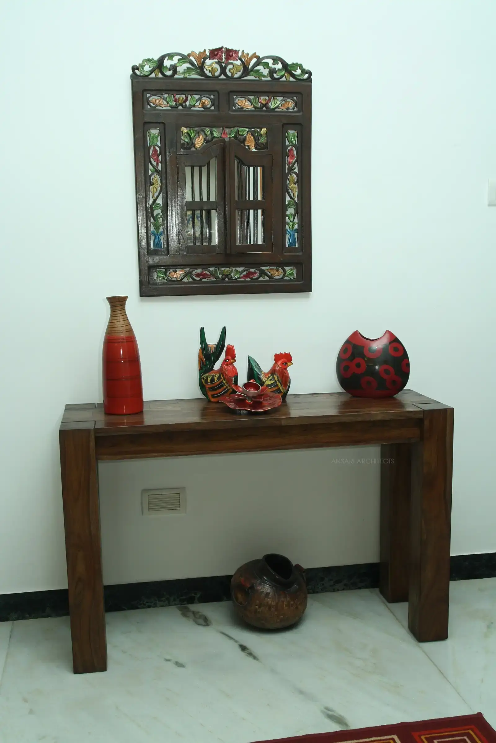 Foyer area is highlighted with a simple table with display of artefacts and wall hanging.