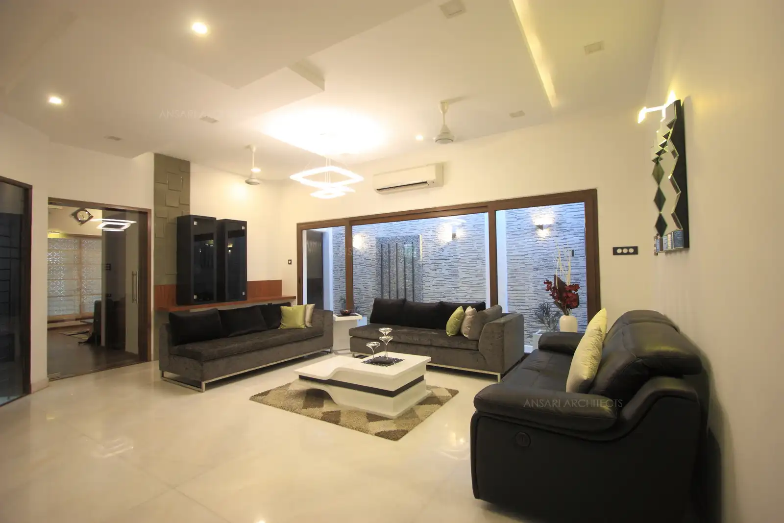 The living room has a huge courtyard divided by large glass partition for natural lighting and aesthetic view.
