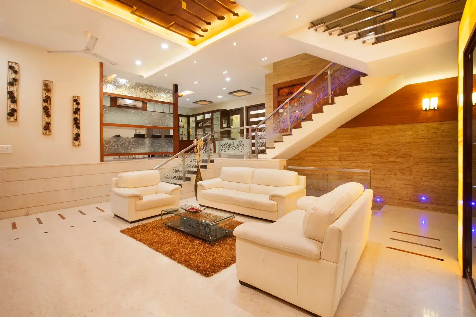 Living room has been distinctively divided with decorative glass partition and glass handrails.