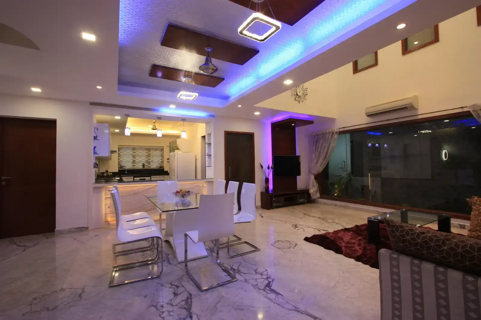 A glass door in the drawing room opens up to a spacious area which has been diveded in to living, dining, an open kitchen and staircase area.