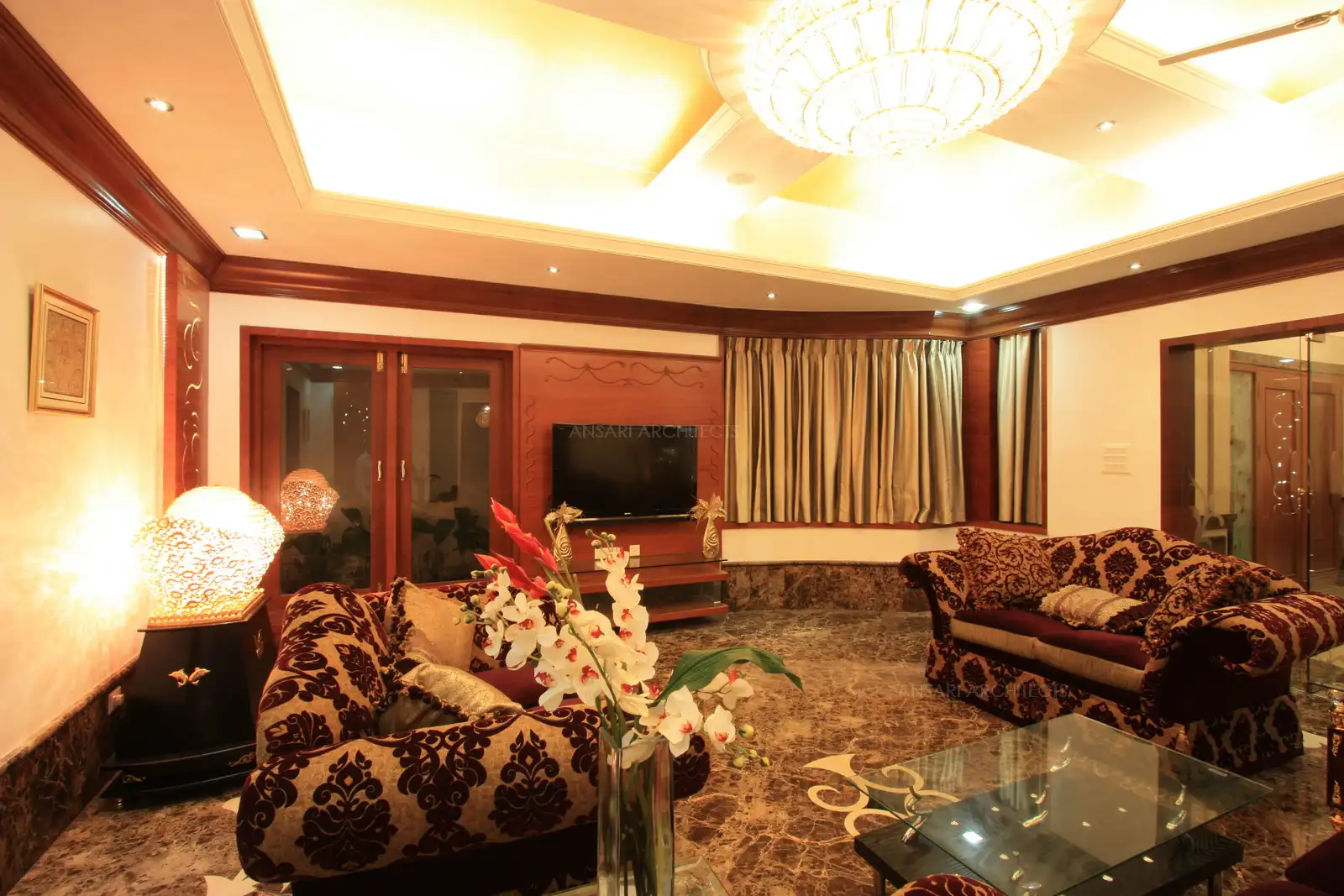 View of drawing room showing the plush furniture, decorative lightings and wooden panelling.