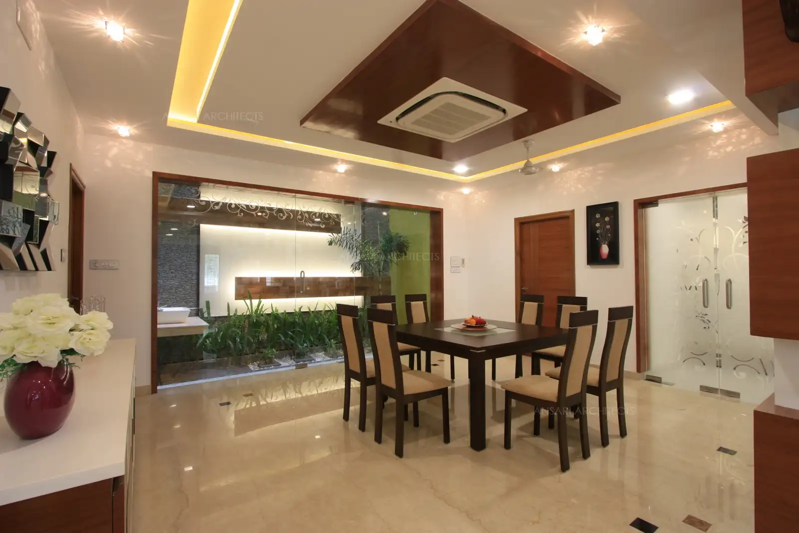 A courtyard in the dining room with natural and artificial lighting brightens up the area and gives an interesting feature to the wall.