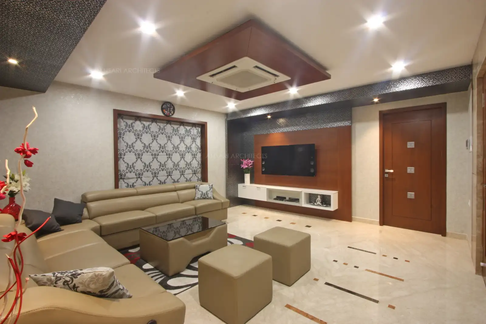 The wooden media unit with storage stands out as a dominant decor feature in this uncluttered living room, the stark colour contrast of the dark brown against the entire room with large cabinets below hold all peripherals.