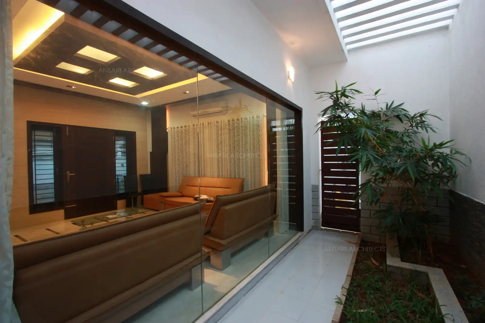Curtains in the drawing room open up to a large glass partition for courtyard view outside.