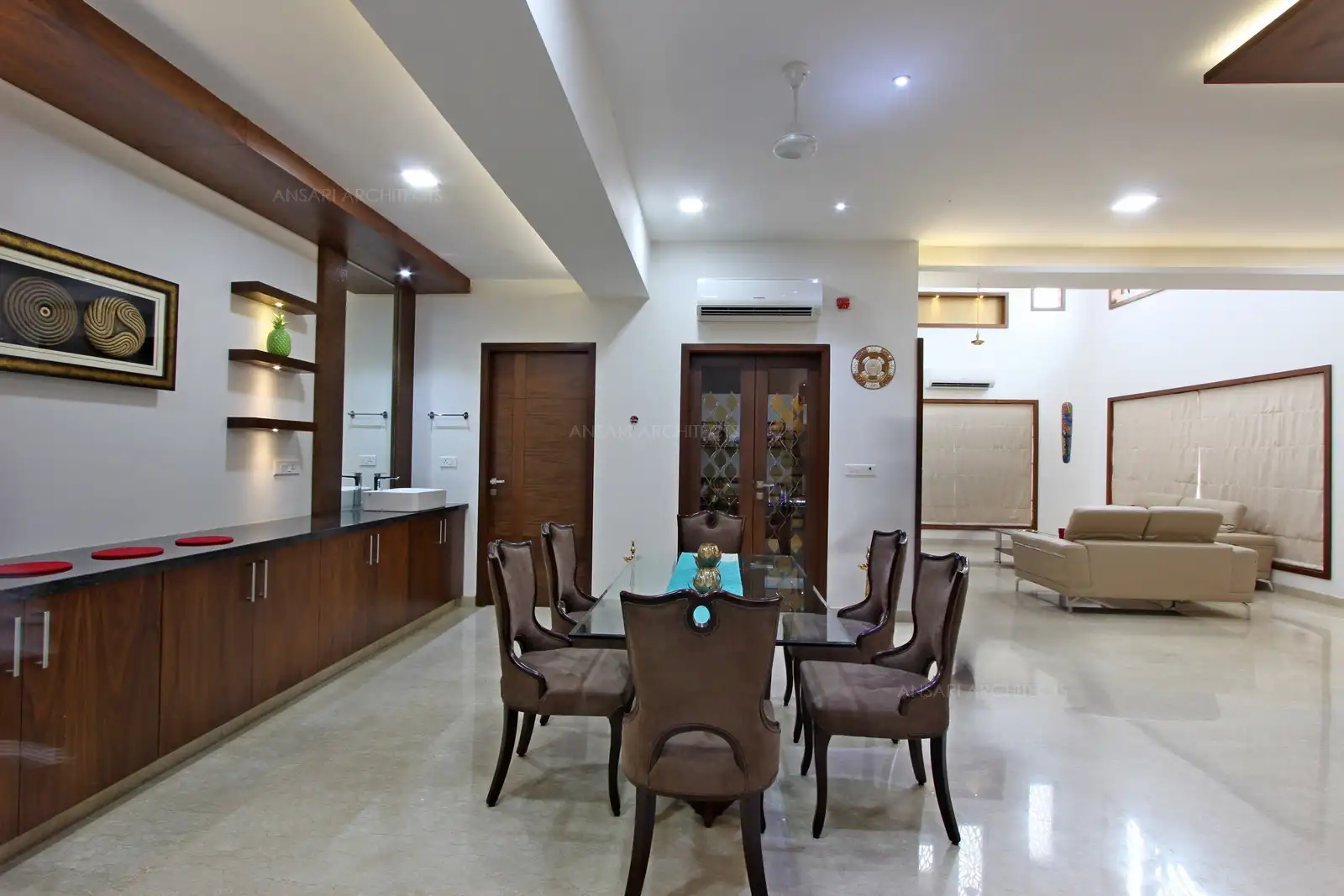 Compact and stramlined storage is used at the dining area along with on-display shelving with dark wood and laminate texture for an uncluttered look .