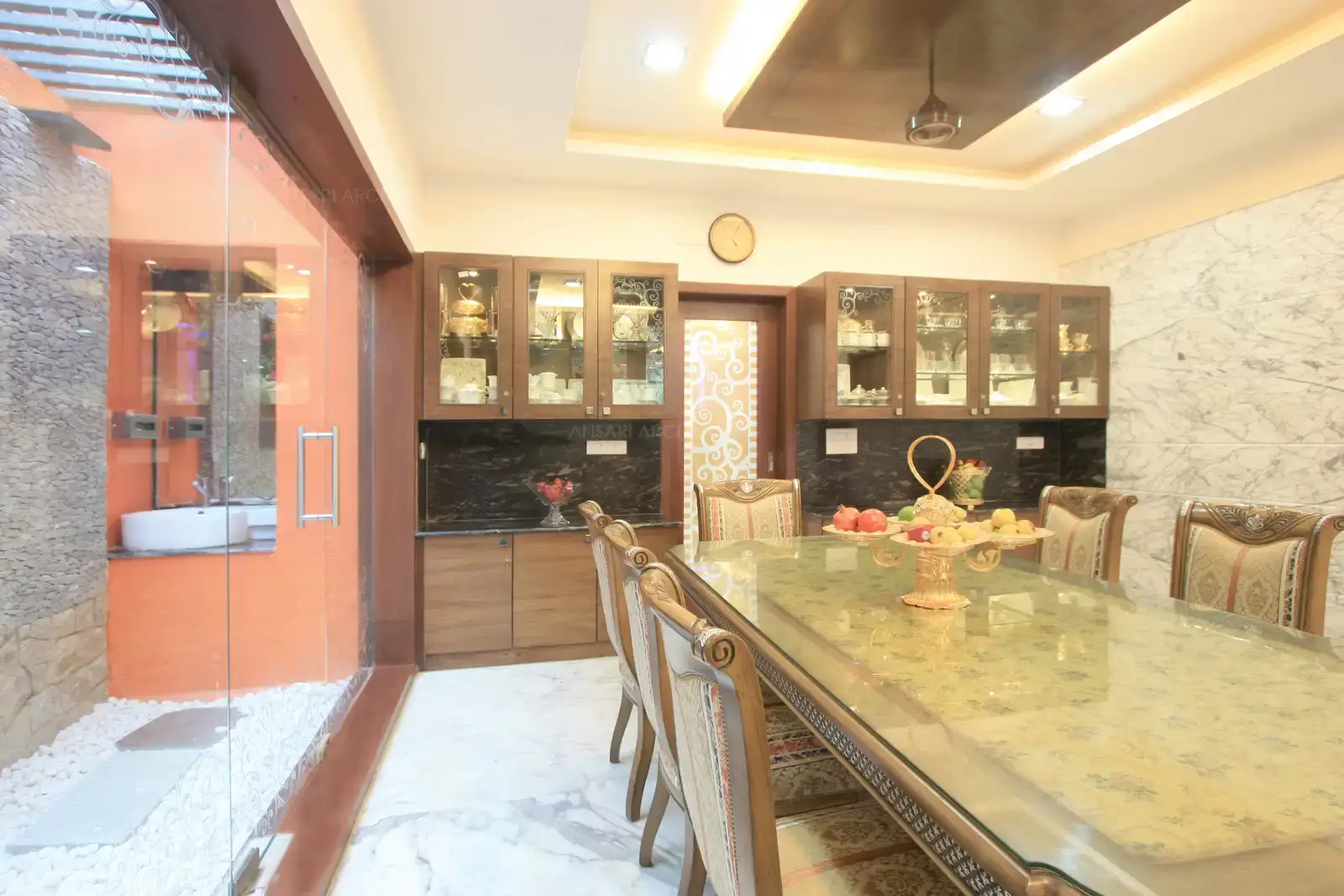 View of dining room showing the courtyard area divided by clear glass partiton.