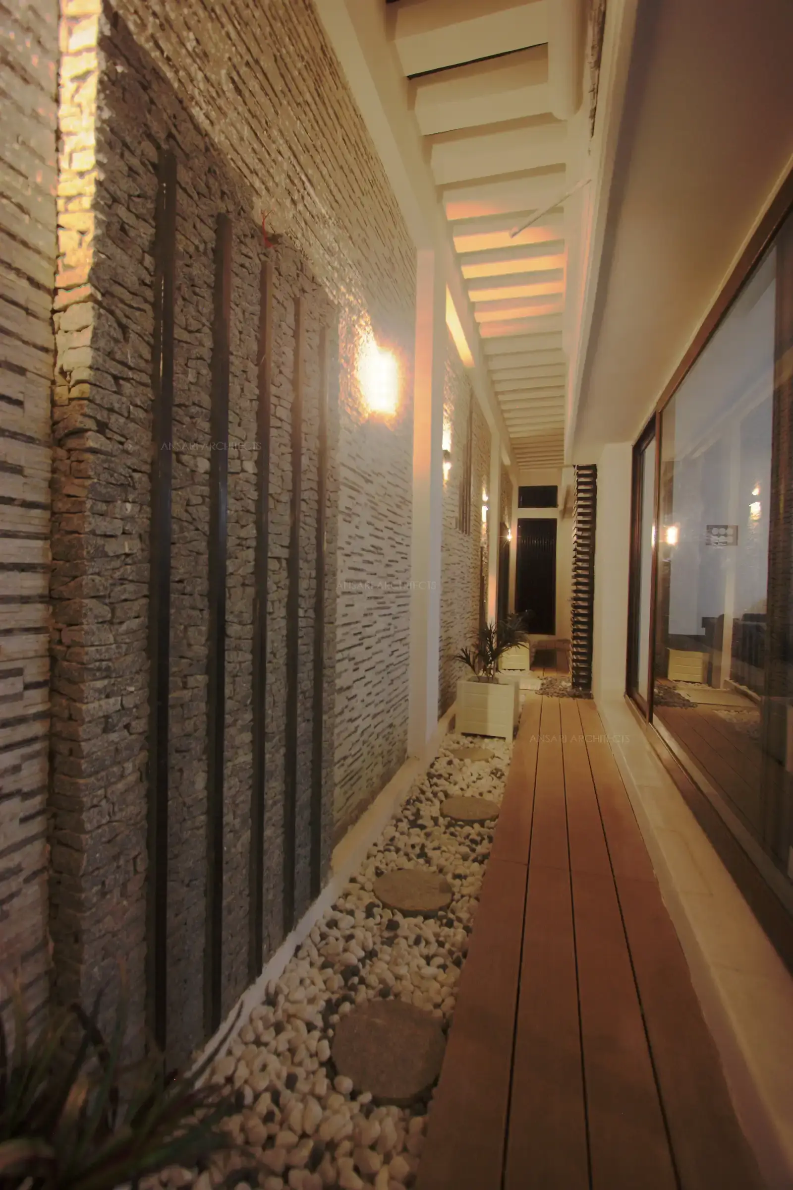 Courtyard with wooden deck and pebble flooring.