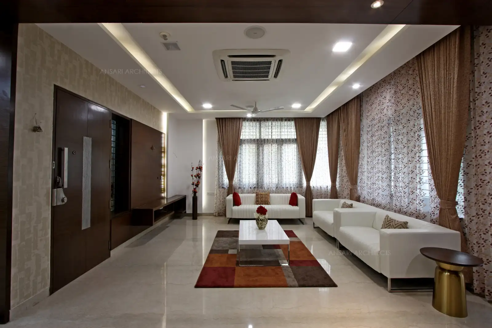 A spacious living room with cassette air conditioner and selected artifacts with the view of simple and sleek false ceiling.