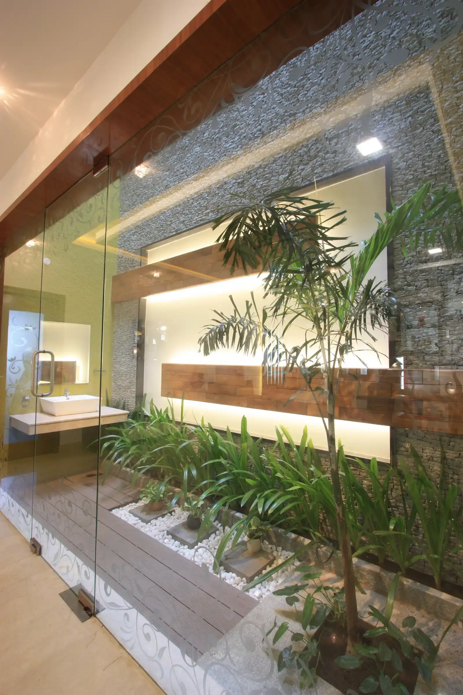View of courtyard from the dining room divided by clear glass.