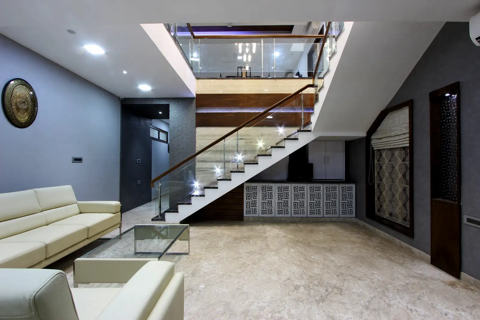 The furnitures glass top table and cushioned sofas looks coordinated and soothing .