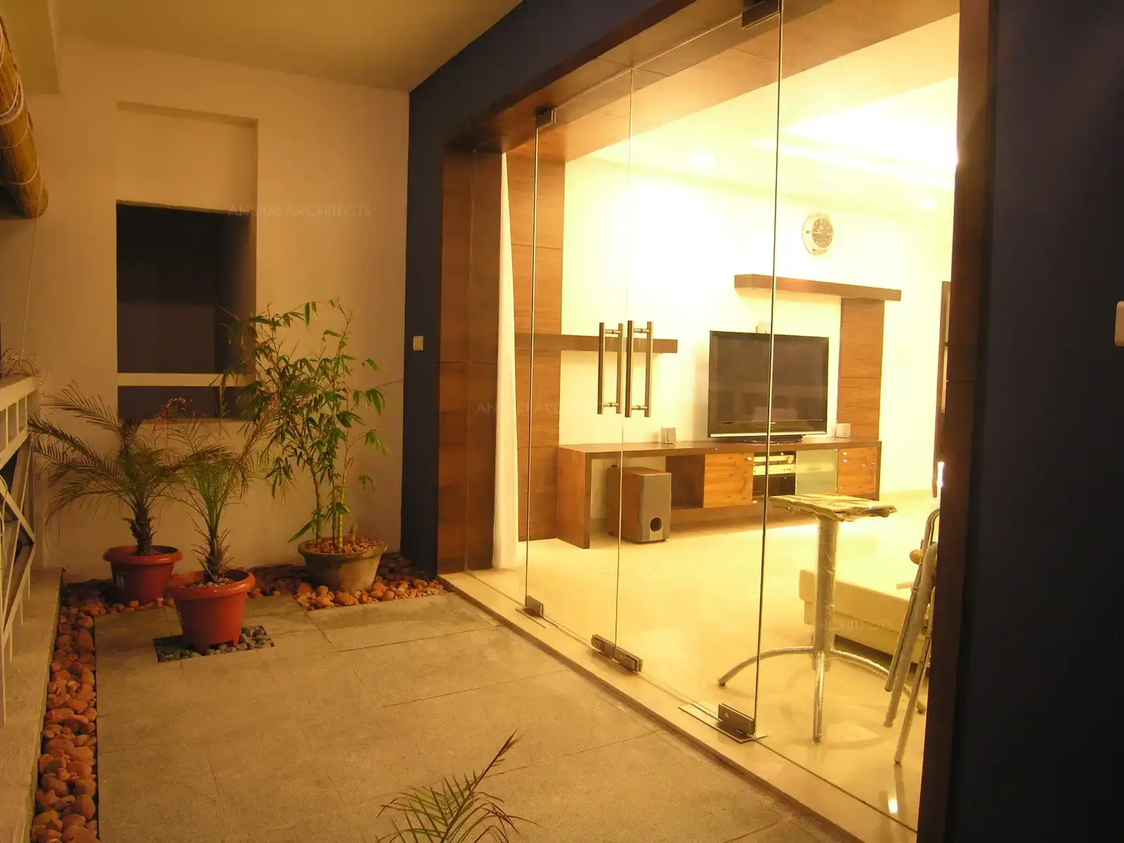 View of living room seen from the balcony which a divided through a full height clear glass door.