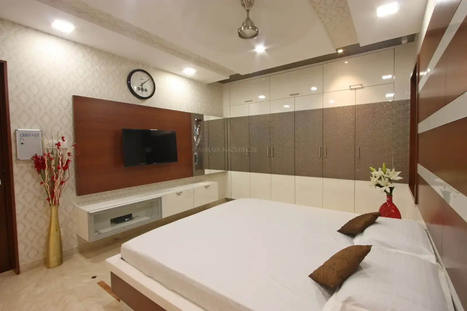 Wallpaper walls and as backdrop embellish the TV unit that breaks away the rustic theme yet false ceiling looks complete with wallpaper insets and recessed spotlights.