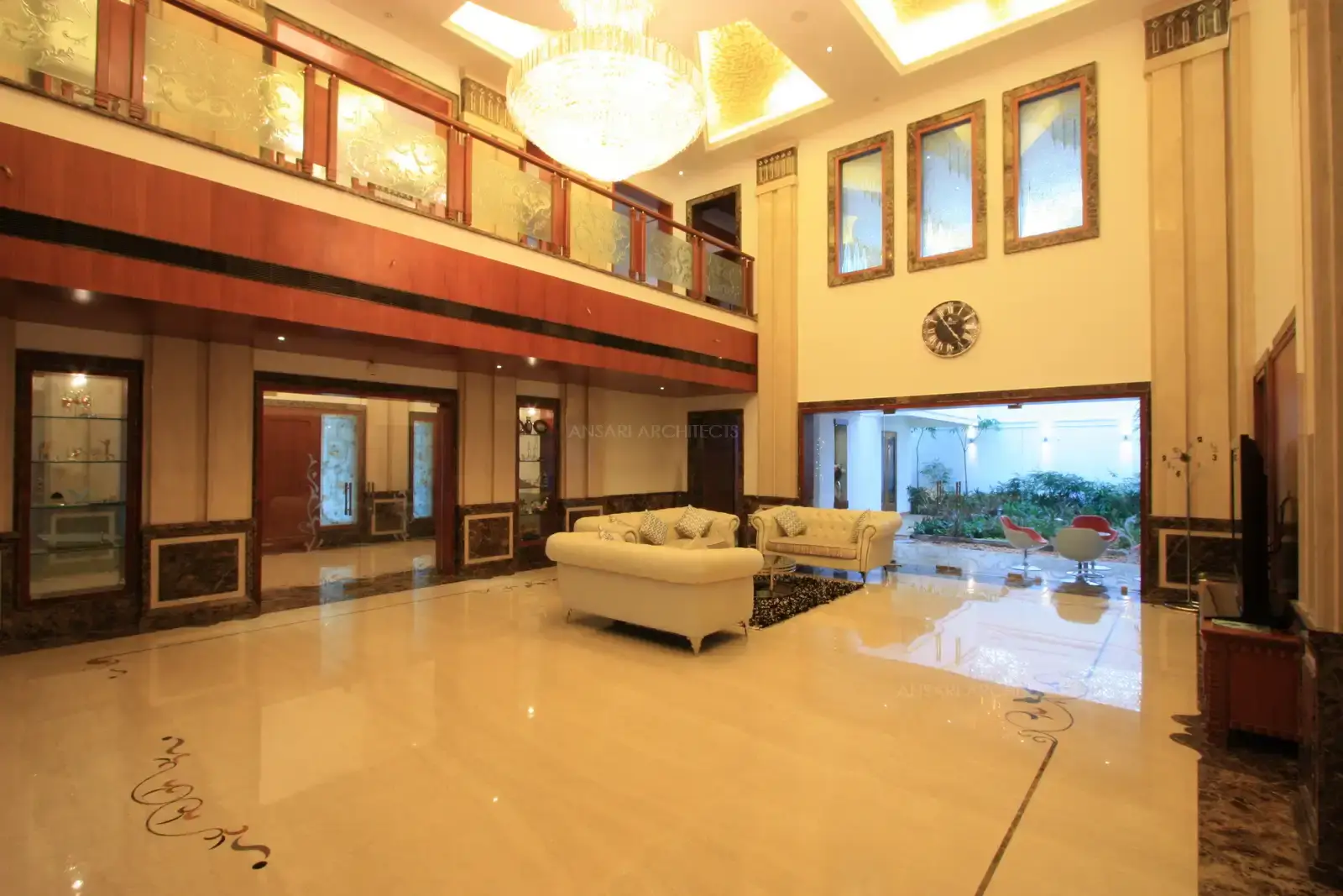 Hand rails designed in textured glass, stailess steel and wooden combination along with royal chandlier in the double height ceiling area add to the luxurious look in the living room.