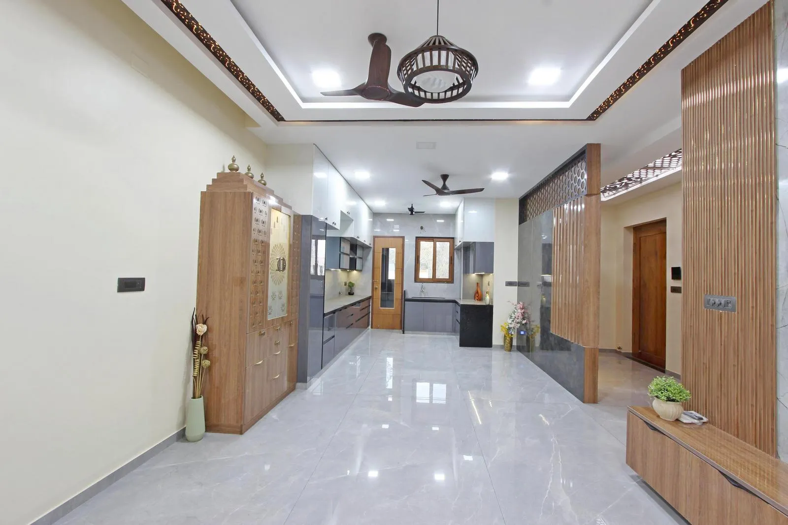 The parallel kitchen layout on the second floor maximizes workflow, with the utility area extending to the balcony for natural light and ventilation. Its linear design defines the cooking zone while maintaining visual continuity and connectivity with the living area.