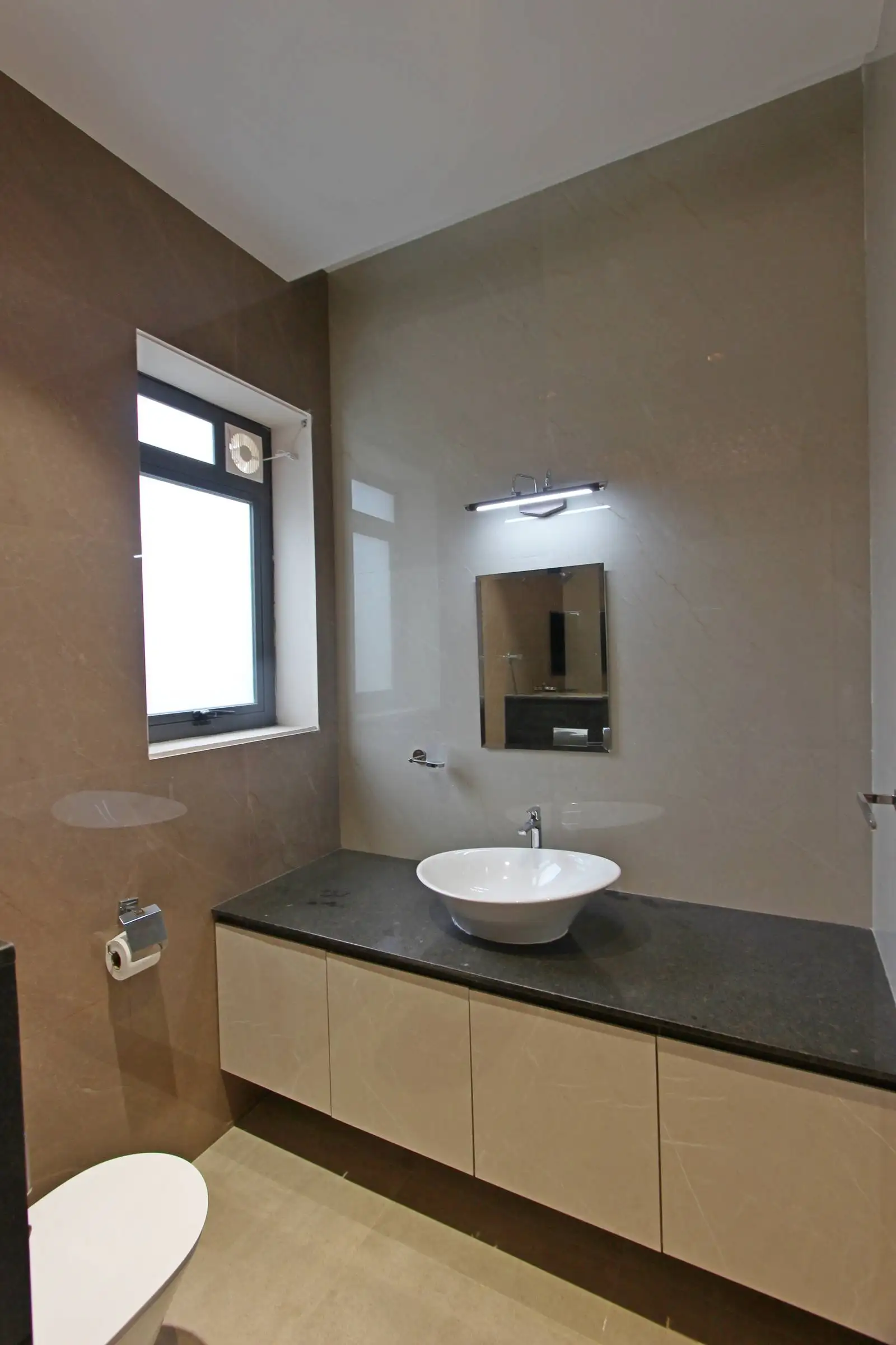 The bathroom showcases a contemporary design with a black countertop, white vessel sink, and a wall-mounted mirror, balanced by warm beige walls and natural light from the window.